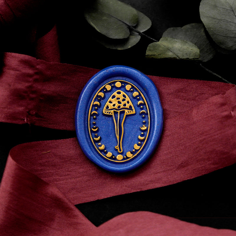 Wax Seal Stamp, created an oval blue wax seal on a red ribbon with moon phases mushroom lady design .