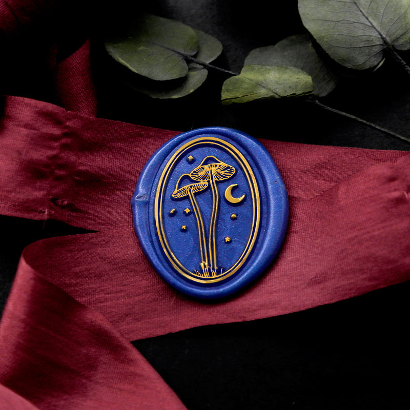Wax Seal Stamp, created an oval blue wax seal on a red ribbon with mushroom moon stars design .