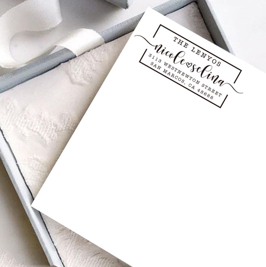A personalized self inking address stamp, customized with your shop name and address, stamped on the white card, a gift box is under it.