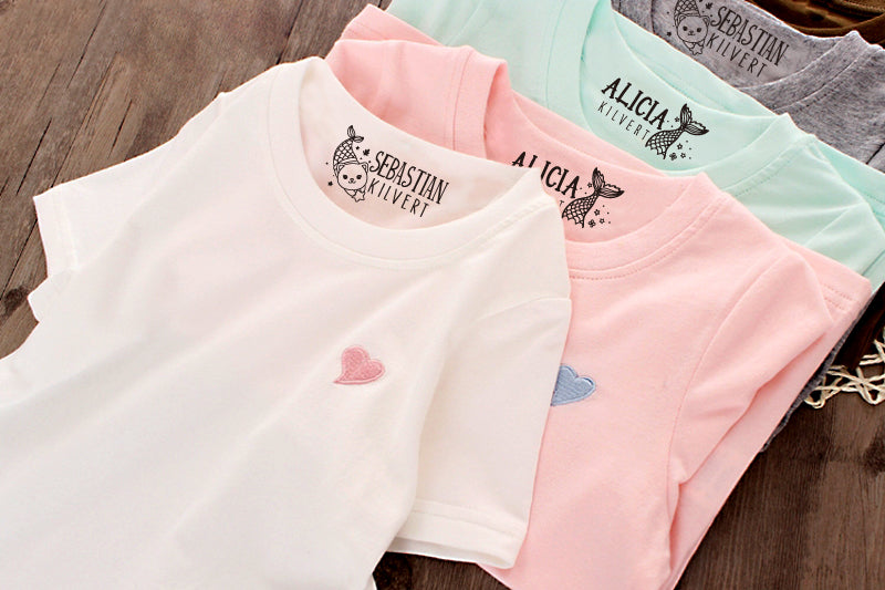 custom clothing stamp, imprinted on the clothes. A cat mermaid with custom name on the white and grey clothes, the mermaid tail with custom name on the pink and mint clothes