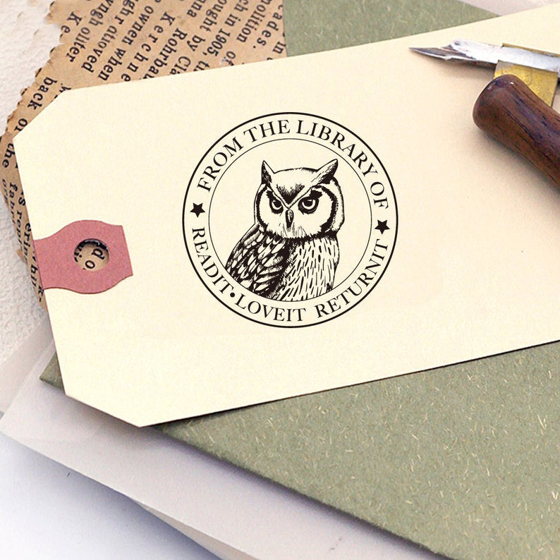 A personalized book stamp, shaped like round, the center is graphic of owl, surrounded with words from the library of and read it. love it. return it.
