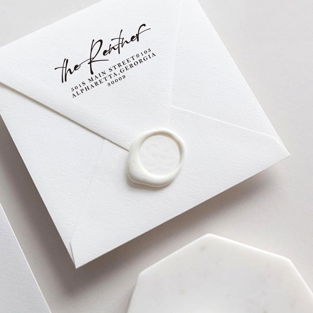 A self inking return address stamp, customized with your name and address, stamped on the white envelop of invitation card, a wax seal sealed the envelope.
