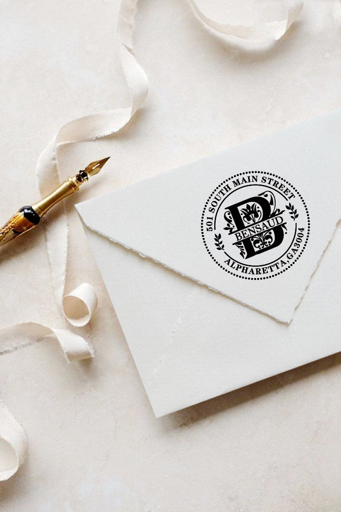 A personalized self inking address stamp, customized with your name, initial, address and leaves, stamped on the white envelop, beside it, a ribbon is waiting for packing the gift.