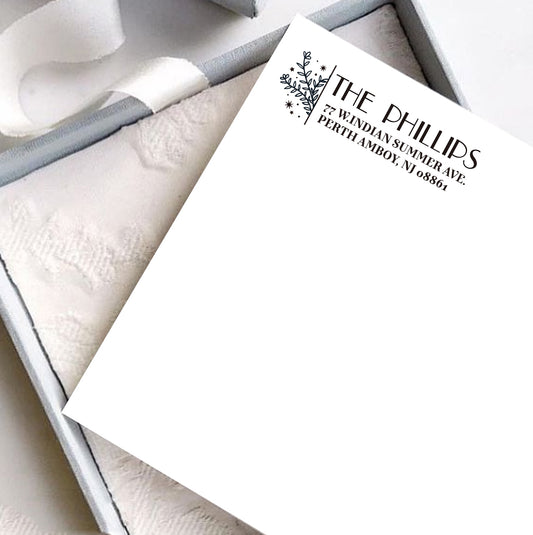 A personalized self inking address stamp, customized with your shop name and address, stamped on the white card, a gift box is under it.