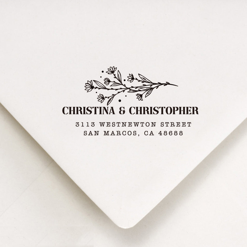 A personalized self inking address stamp, customized with your name, flower and address, stamped on the white envelope.