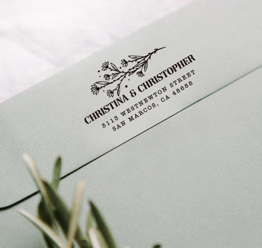 A personalized self inking address stamp, customized with your name, address and flower, stamped on the gray envelope.