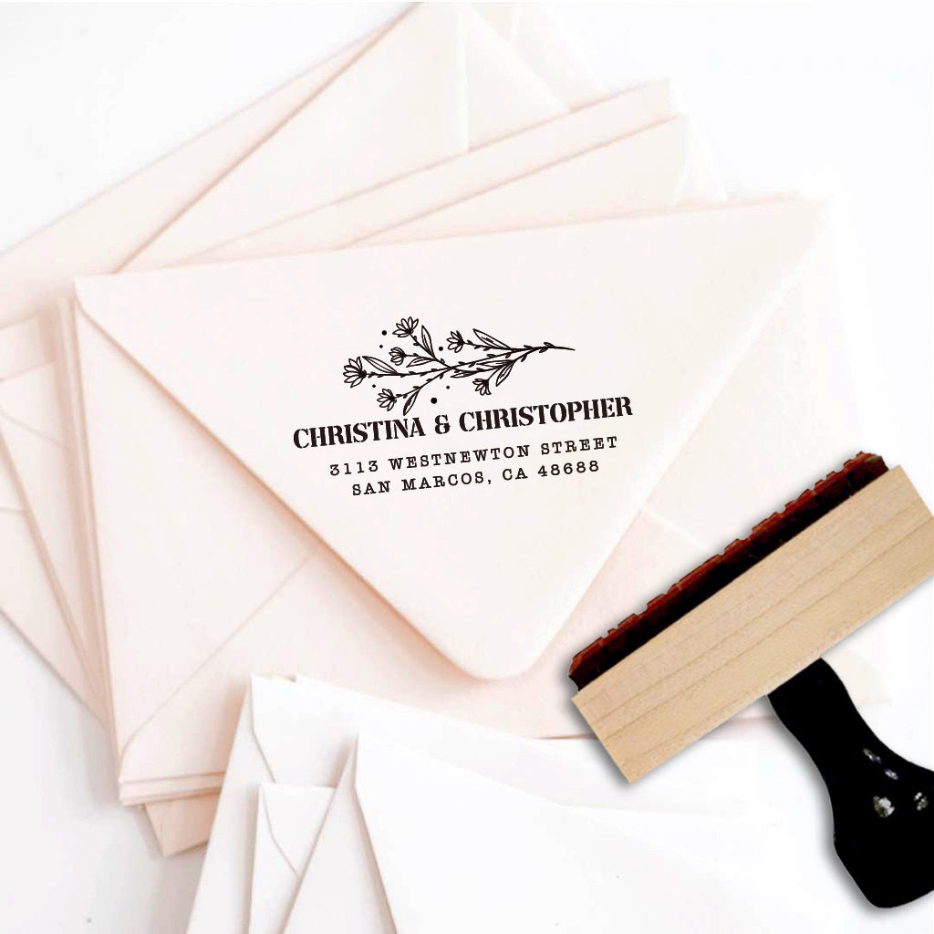 A personalized self inking address stamp, customized with your name, address and flower, stamped on the pink envelope.