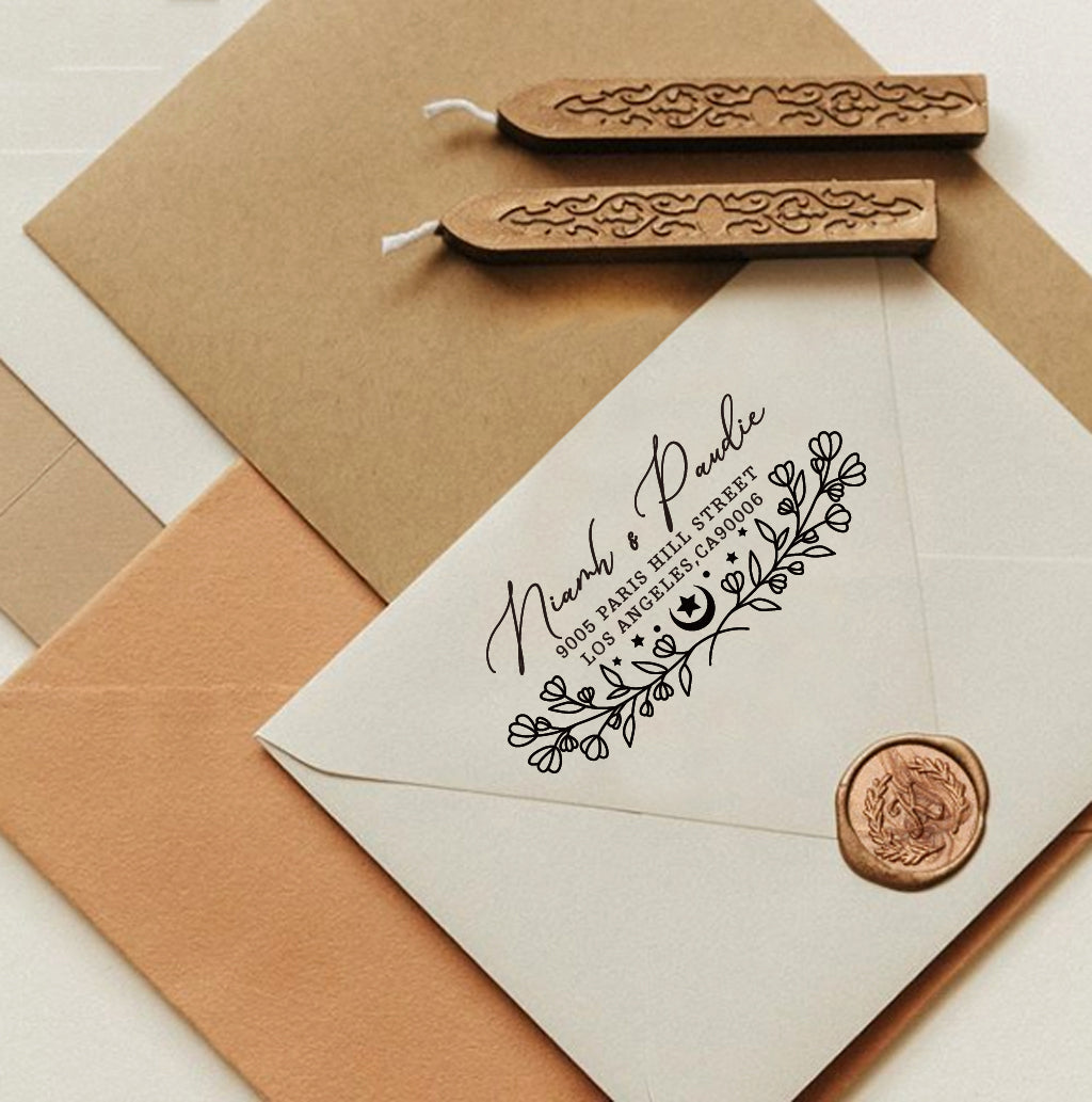 A personalized self inking return address stamp, customized with your name, address and flower, stamped on the white envelope, beside it, sealing wax is creating a wax seal on the mail.