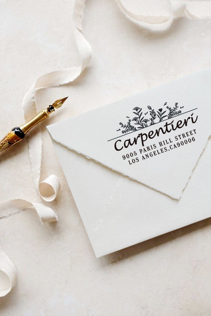 A personalized self inking address stamp, customized with your name, address and flower, stamped on the white envelop, beside it, a ribbon is waiting for packing the gift.