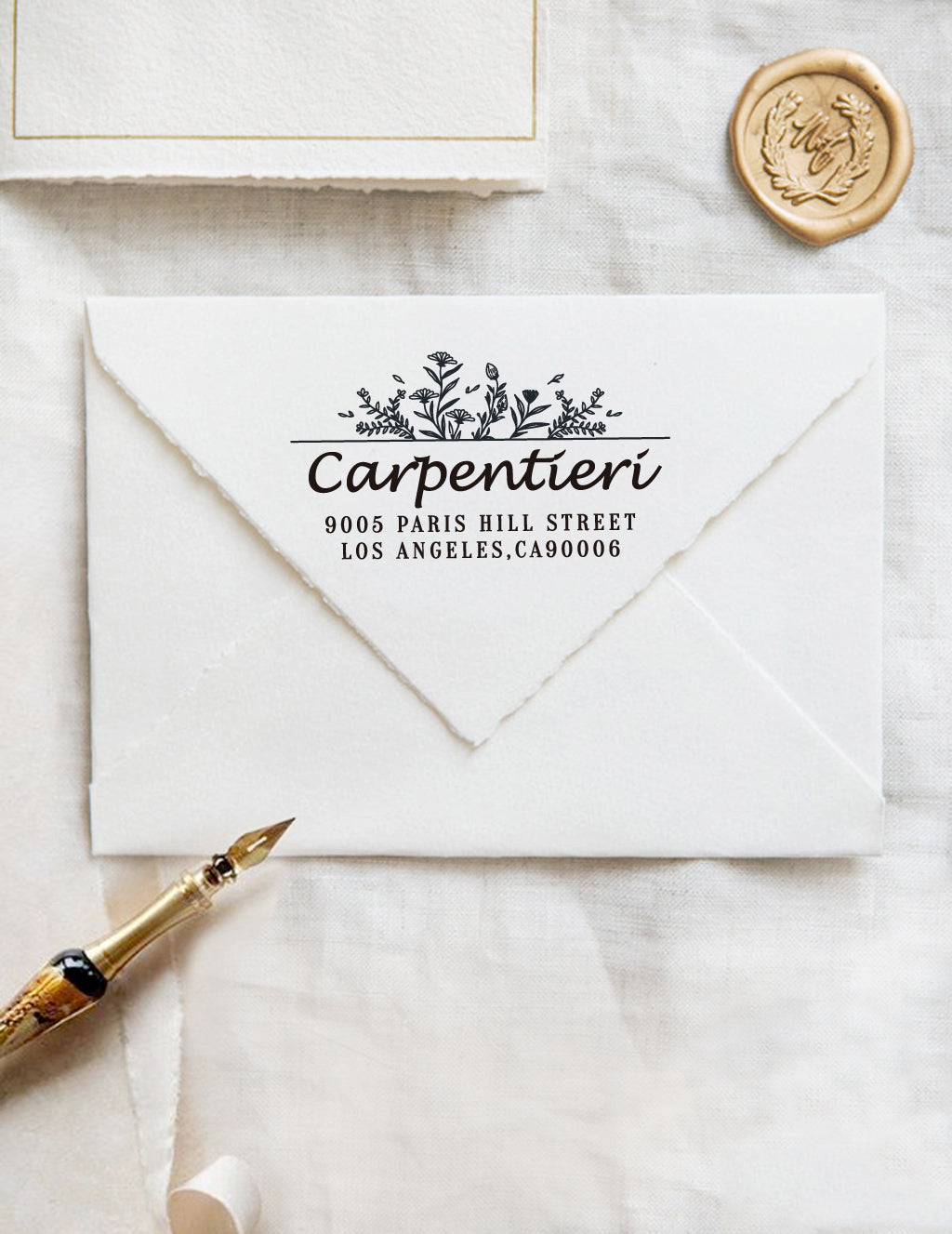 A personalized self inking wedding address stamp, customized with your name, address and flower, stamped on the white envelope, beside it, a wax seal is waiting for sealing the mail.
