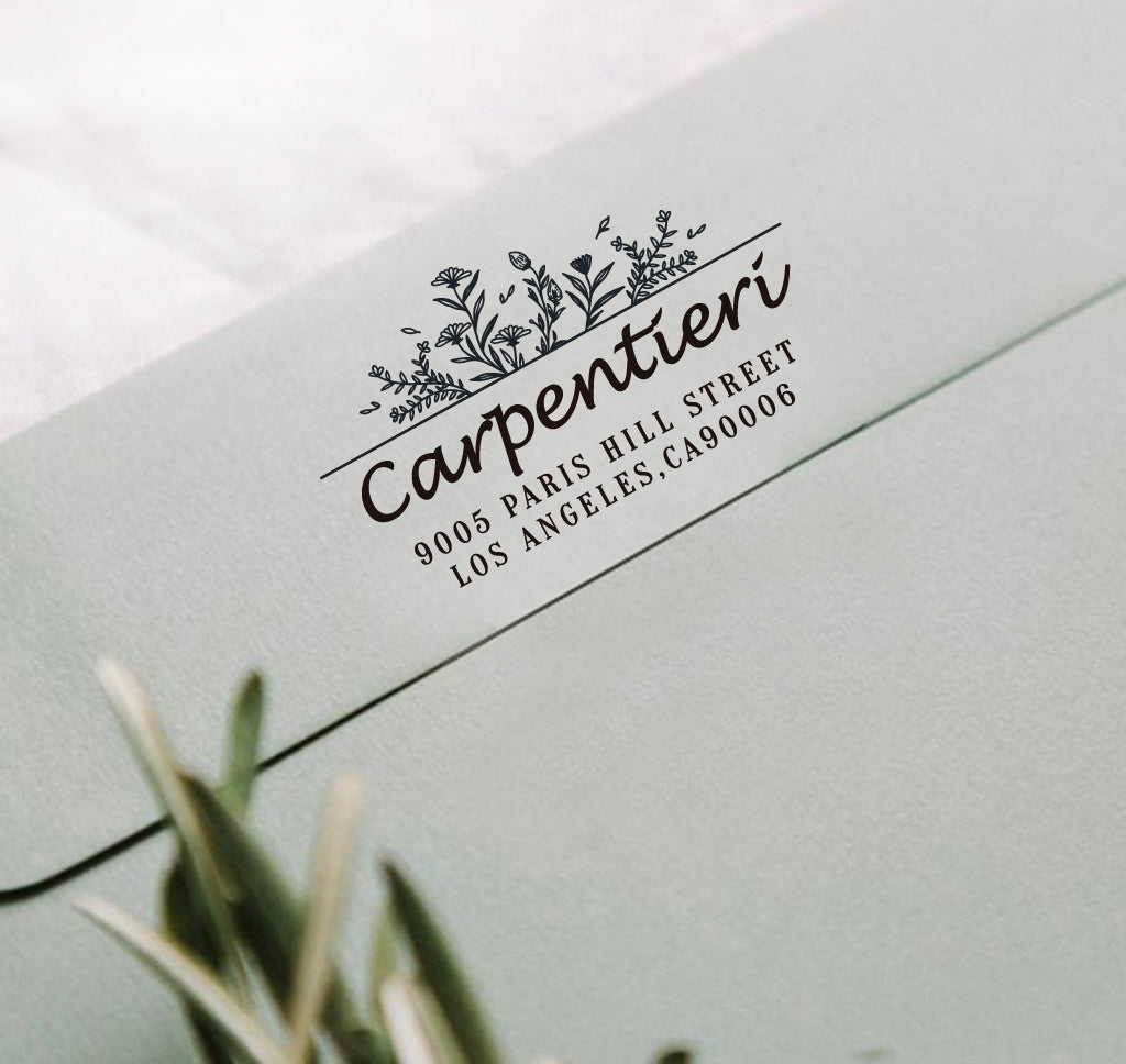 A personalized self inking address stamp, customized with your name, address and flower, stamped on the gray envelope.