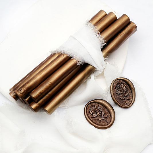 Sealing Wax Sticks in antique bronze with white wedding packing cloth wrapped, beside them, two rose flower pattern wax seals samples created.