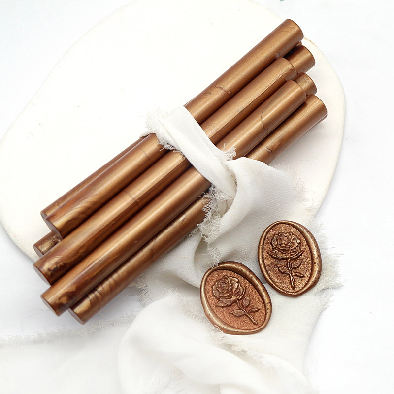 Sealing Wax Sticks in red copper with white wedding packing cloth wrapped, beside them, two rose flower pattern wax seals samples created.