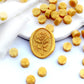 Some gold wax beads placed on white cushion and cloth, and an wax seal created with them.