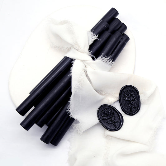 Sealing Wax Sticks in black with white wedding packing cloth wrapped, beside them, two rose flower pattern wax seals samples created.