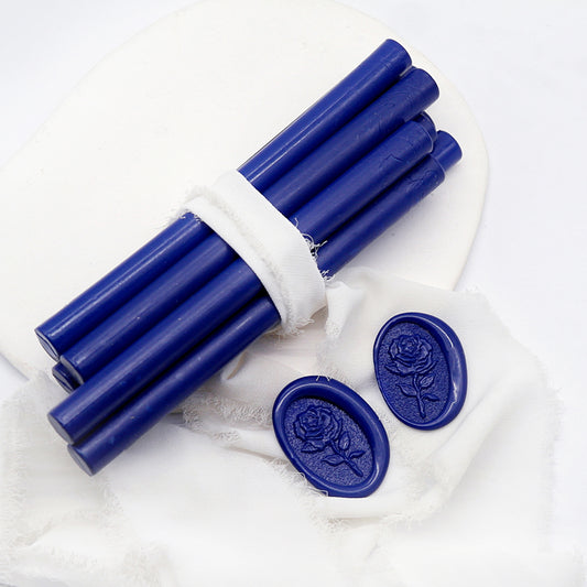 Sealing Wax Sticks in Midnight Blue with white wedding packing cloth wrapped, beside them, two rose flower pattern wax seals samples created.