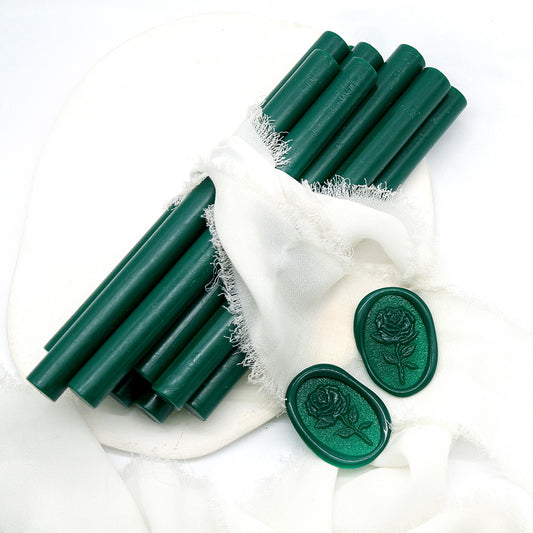 Sealing Wax Sticks in dark green with white wedding packing cloth wrapped, beside them, two rose flower pattern wax seals samples created.