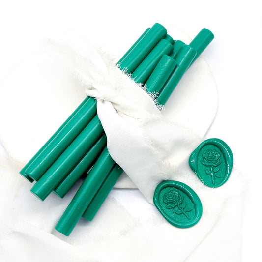 Sealing Wax Sticks in emerald green with white wedding packing cloth wrapped, beside them, two rose flower pattern wax seals samples created.