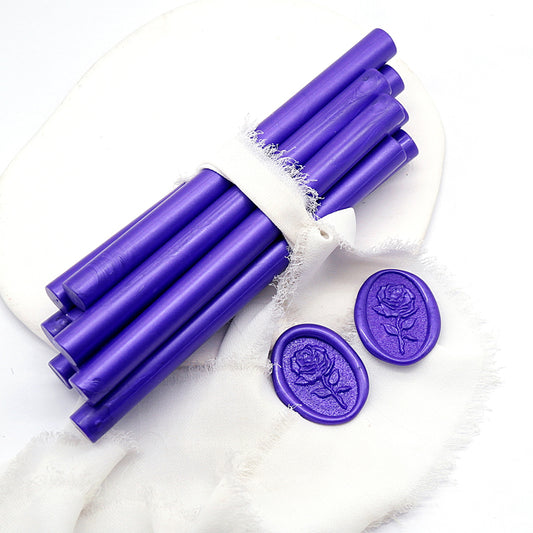Sealing Wax Sticks in metallic purple with white wedding packing cloth wrapped, beside them, two rose flower pattern wax seals samples created.
