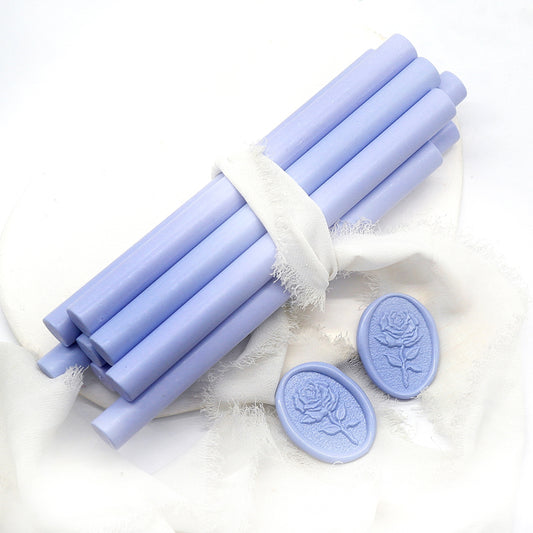 Sealing Wax Sticks in cornflower blue with white wedding packing cloth wrapped, beside them, two rose flower pattern wax seals samples created.