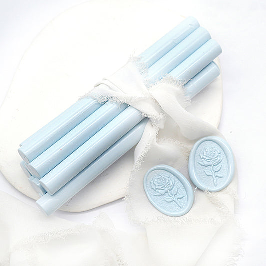 Sealing Wax Sticks in ice blue with white wedding packing cloth wrapped, beside them, two rose flower pattern wax seals samples created.