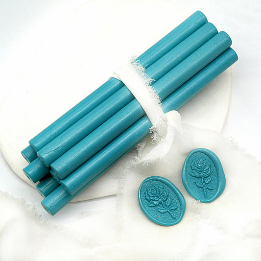 Sealing Wax Sticks in Teal blue with white wedding packing cloth wrapped, beside them, two rose flower pattern wax seals samples created.