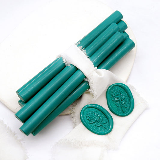 Sealing Wax Sticks in teal green with white wedding packing cloth wrapped, beside them, two rose flower pattern wax seals samples created.