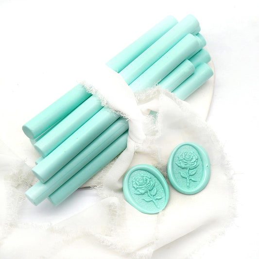 Sealing Wax Sticks in mint green with white wedding packing cloth wrapped, beside them, two rose flower pattern wax seals samples created.
