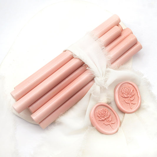 Sealing Wax Sticks in pale pink with white wedding packing cloth wrapped, beside them, two rose flower pattern wax seals samples created.