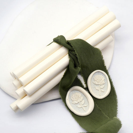 Sealing Wax Sticks in cream with dark green wedding packing cloth wrapped, beside them, two rose flower pattern wax seals samples created.