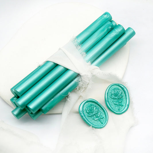 Sealing Wax Sticks in aqua green with white wedding packing cloth wrapped, beside them, two rose flower pattern wax seals samples created.