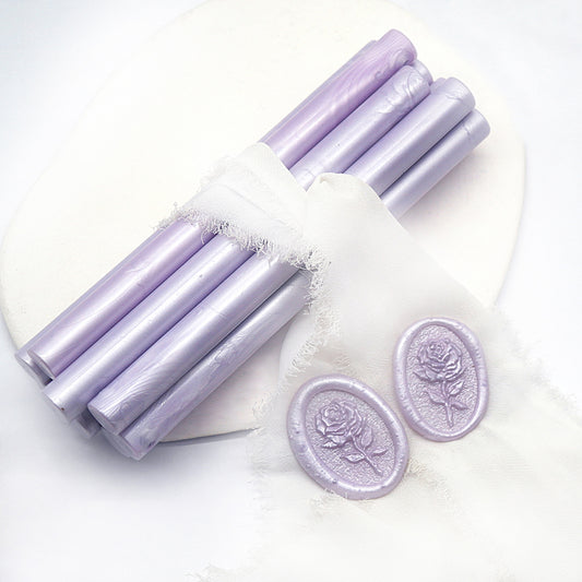 Sealing Wax Sticks in Lilac with white wedding packing cloth wrapped, beside them, two rose flower pattern wax seals samples created.