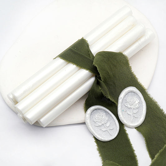 Sealing Wax Sticks in Pearlescent White with dark green wedding packing cloth wrapped, beside them, two rose flower pattern wax seals samples created.