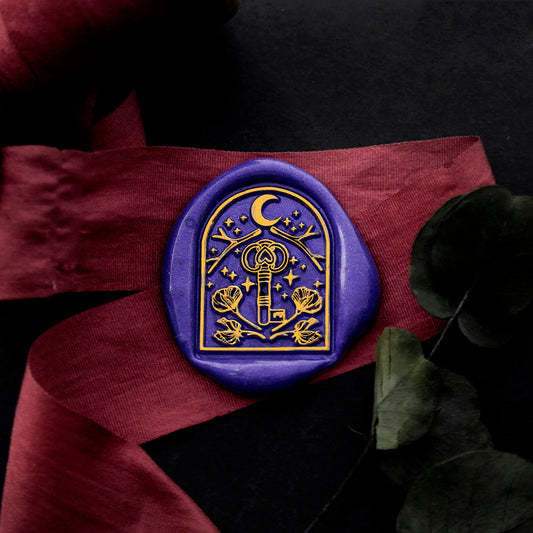 Wax Seal Stamp, created a blue wax seal on a red ribbon with arch window moon key stars flower antlers design .