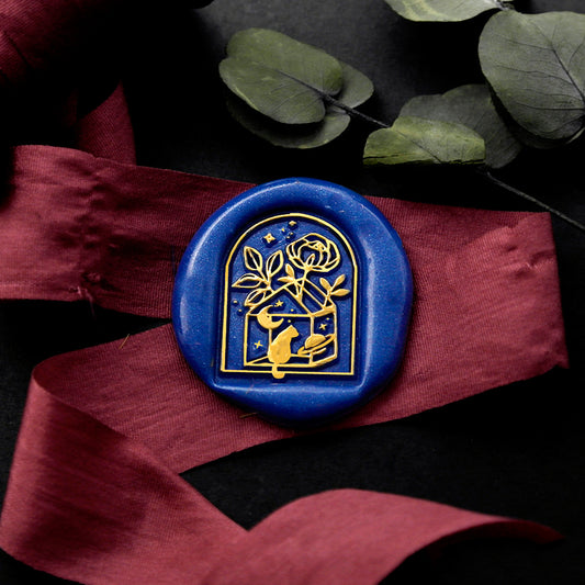 Wax Seal Stamp, created a blue wax seal on a red ribbon with arch door window moon stars cat and flower design .