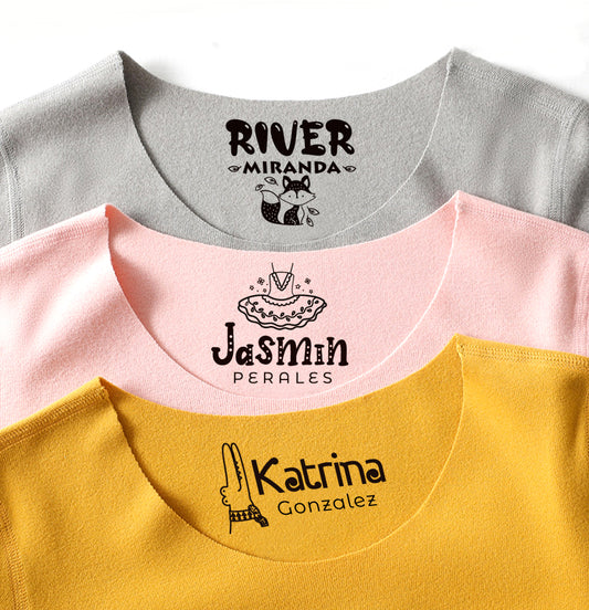 3 styles custom clothing stamps stamped on 3 colors T-shirts, A crocodile with cutom name at right in the yellow clothes at the bottom. A ballet dress with the custom name at the bottom on the pink clothing at the middle. A fox with the name above at the grey clothing at top.