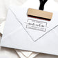 A personalized self inking return address stamp, customized with your name and address, stamped on the white envelope.