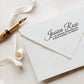 A personalized self inking address stamp, customized with your name and address, stamped on the white envelop, beside it, a ribbon is waiting for packing the gift.