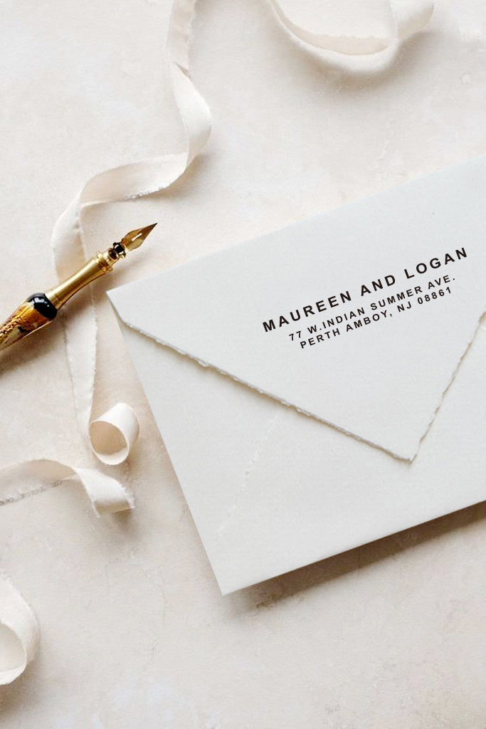 A personalized wedding self inking address stamp, customized with your name and address, stamped on the white envelop, beside it, a ribbon is waiting for packing the gift.