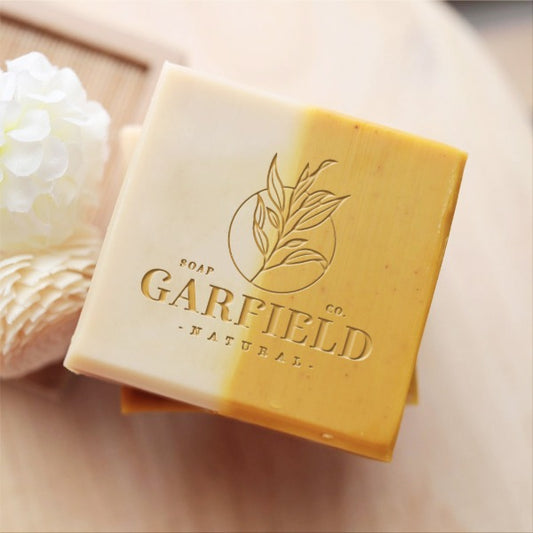 Custom Soap Stamp, with sun, flower, and "natural soap.co" design, imprinted on handmade soap.
