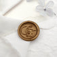 A wax seal with personalized calligraphy initials on the  white cloth.