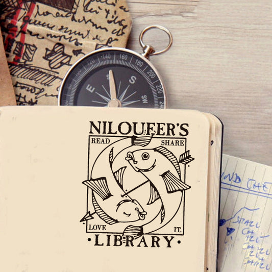 A personalized book stamp in square, love, read, share, it on each corner, and two arrow fishes in the centre, the top is to custom your library name.