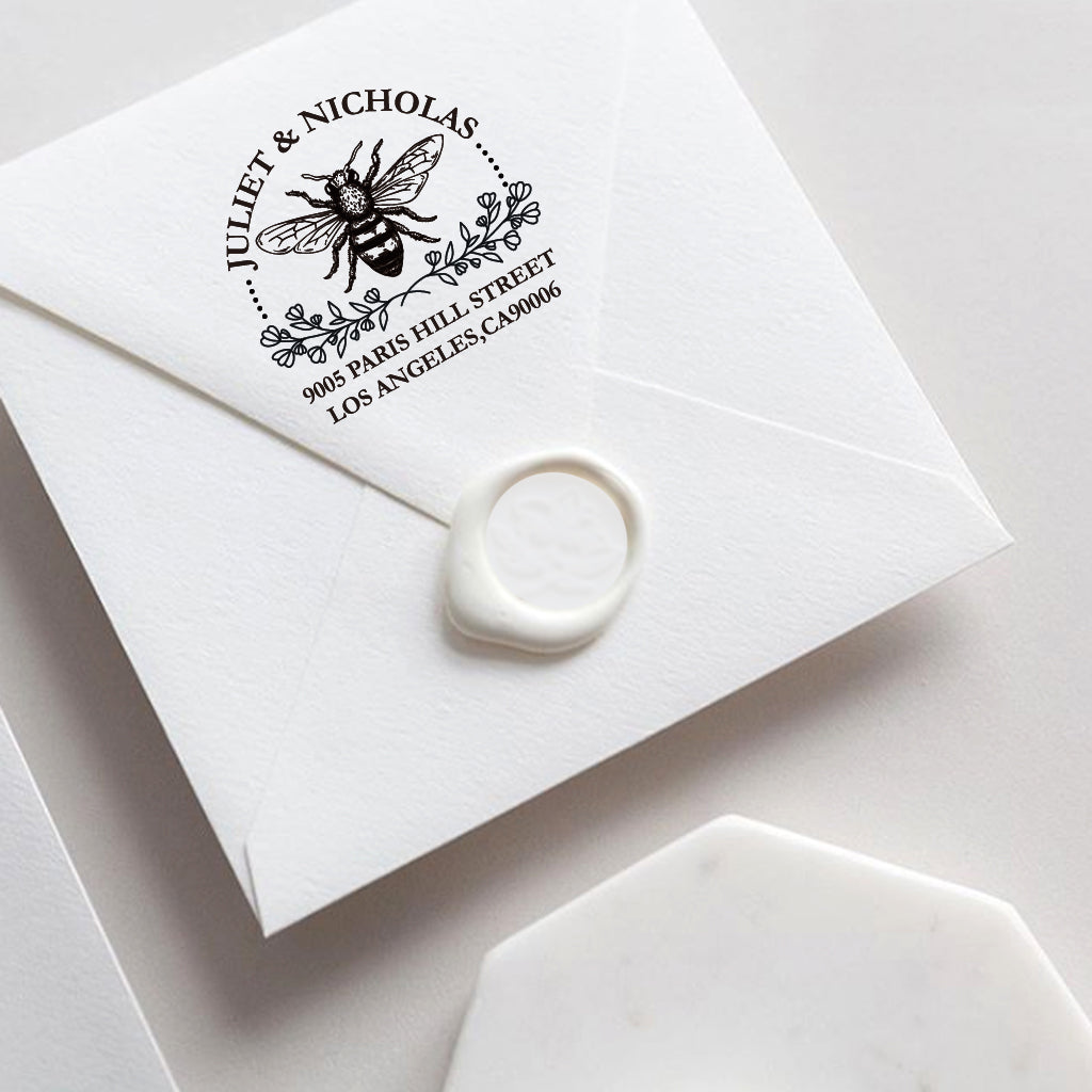 A self inking return address stamp, customized with your name and address, bee and flower, stamped on the white envelop of invitation card, a wax seal sealed the envelope.