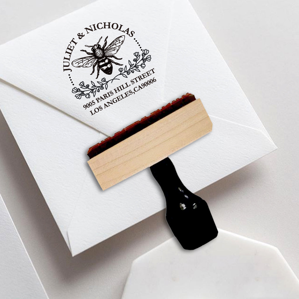 A personalized self inking address stamp, customized with your name and address, bee and flower, stamped on the white envelope of invitation card.