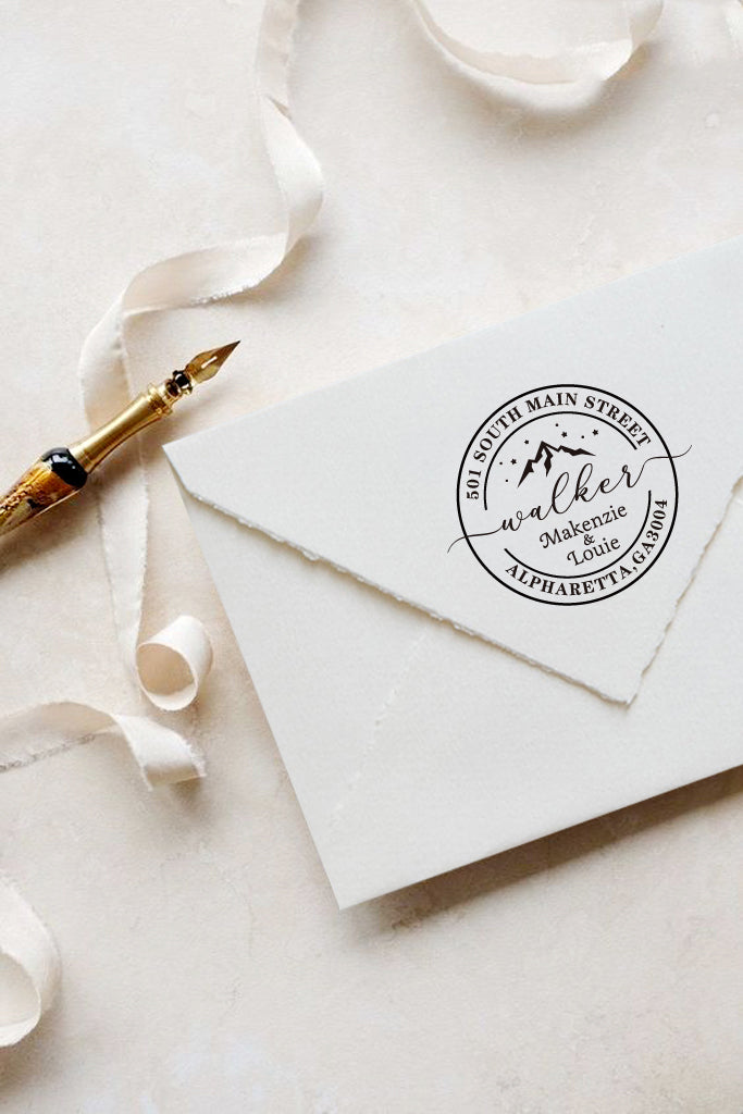 A personalized self inking address stamp, customized with your name, address and mountain, stamped on the white envelop, beside it, a ribbon is waiting for packing the gift.