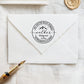 A personalized self inking wedding address stamp, customized with your name, address and mountain, stamped on the white envelope, beside it, a wax seal is waiting for sealing the mail.