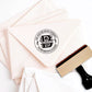 A personalized self inking address stamp, customized with your name, Initial, leaves and address, stamped on the pink envelope.