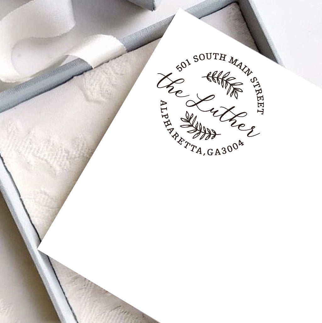 A personalized self inking address stamp, customized with your shop name and address, stamped on the white card, a gift box is under it.