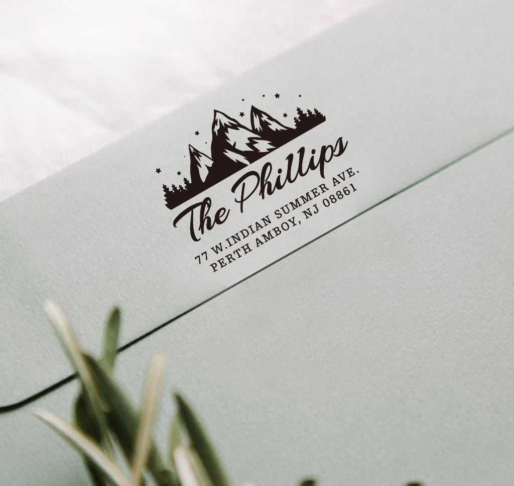 A personalized self inking return address stamp, customized with your mountain logo name and address, stamped on the gray envelope.