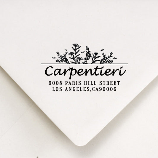 A personalized self inking address stamp, customized with your name, flower and address, stamped on the white envelope.
